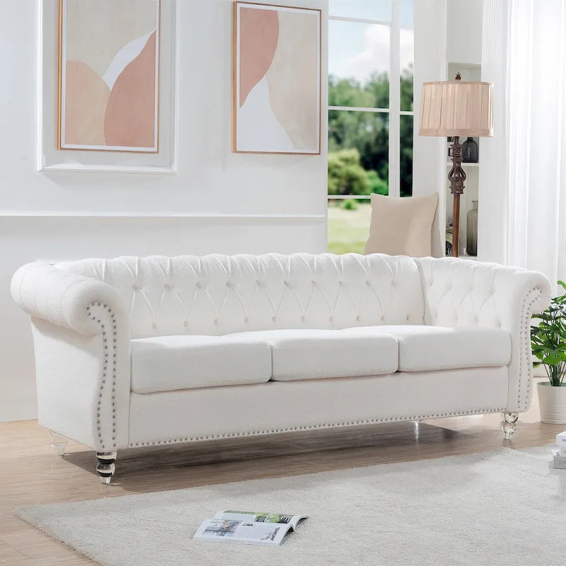Biała tapicerowana sofa z pikowaniem guzikowym i zaokrąglonymi podłokietnikami